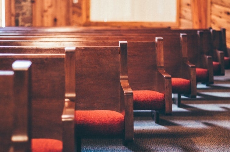 rows of pews with red cushioned seats