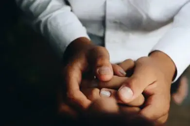 Doctor holding the hands of child patient